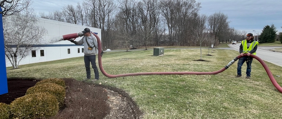 Professionals applying root protection barrier to landscape in Ohio.