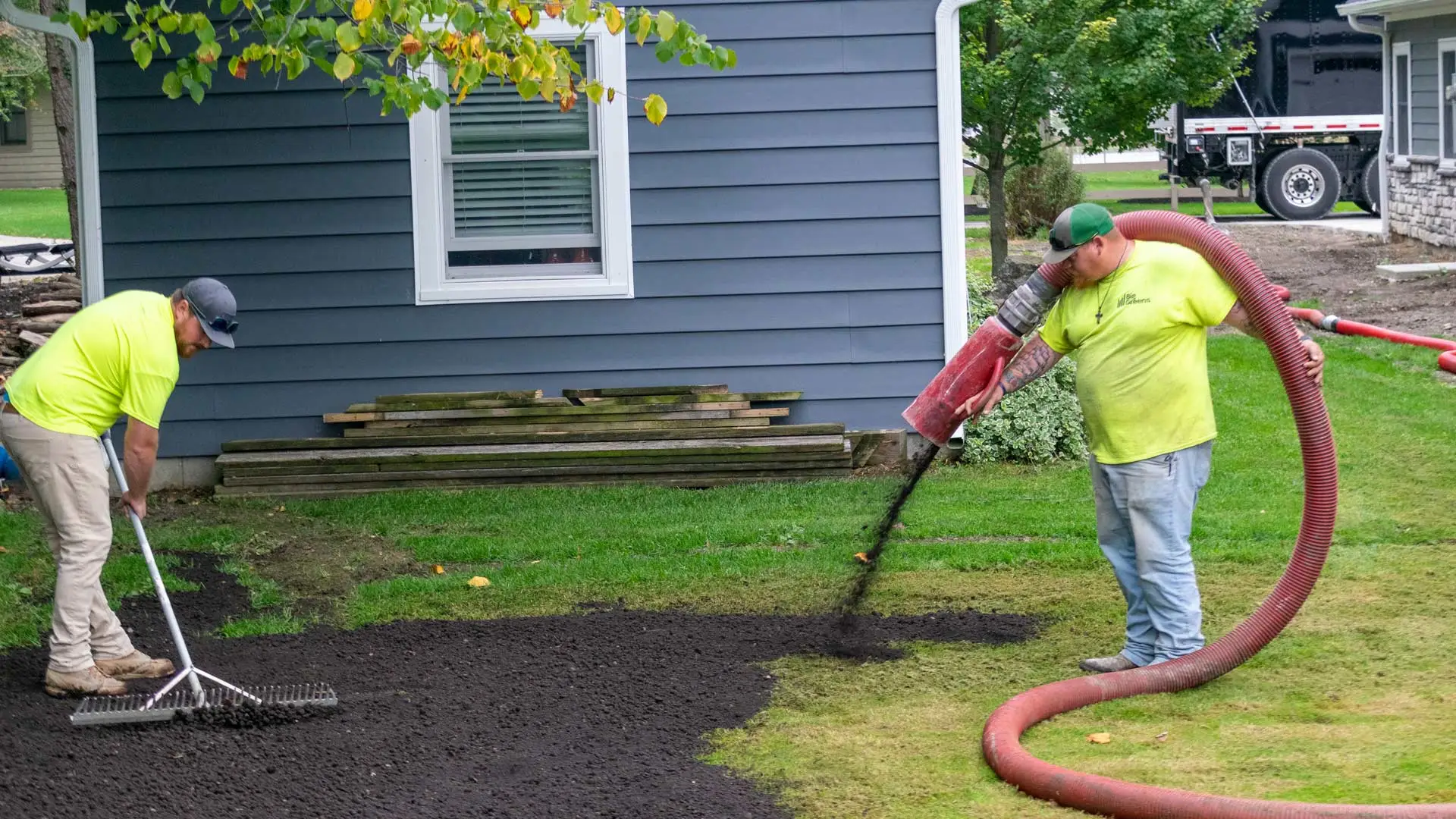 Two workers from Big Greens terraseeding a lawn in Ohio.