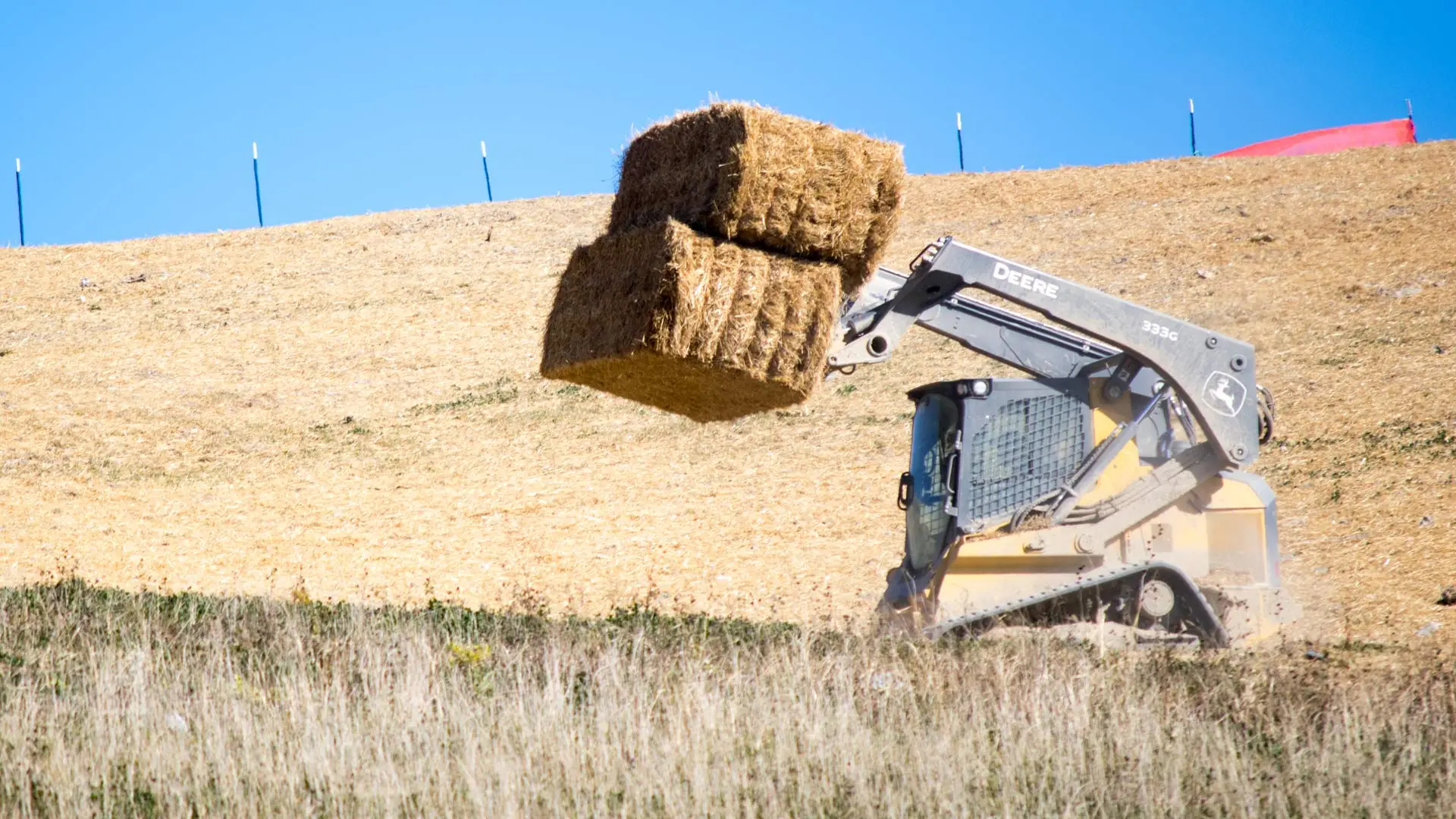Straw being hauled by machinery in a field in Indiana.